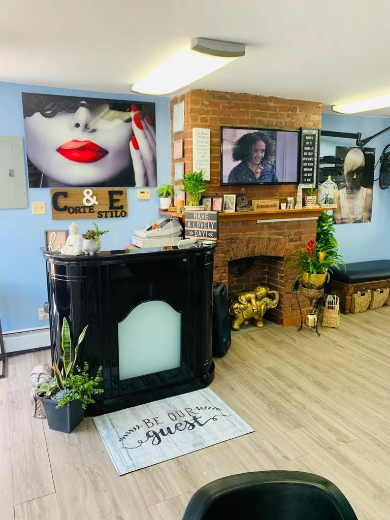 The front room: a black lacquer reception desk, sky-blue walls, a red-brick fireplace wall and a large red-lips print
