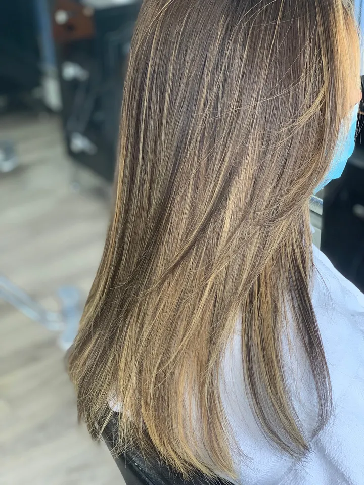 Long layers with a soft honey balayage, worn straight