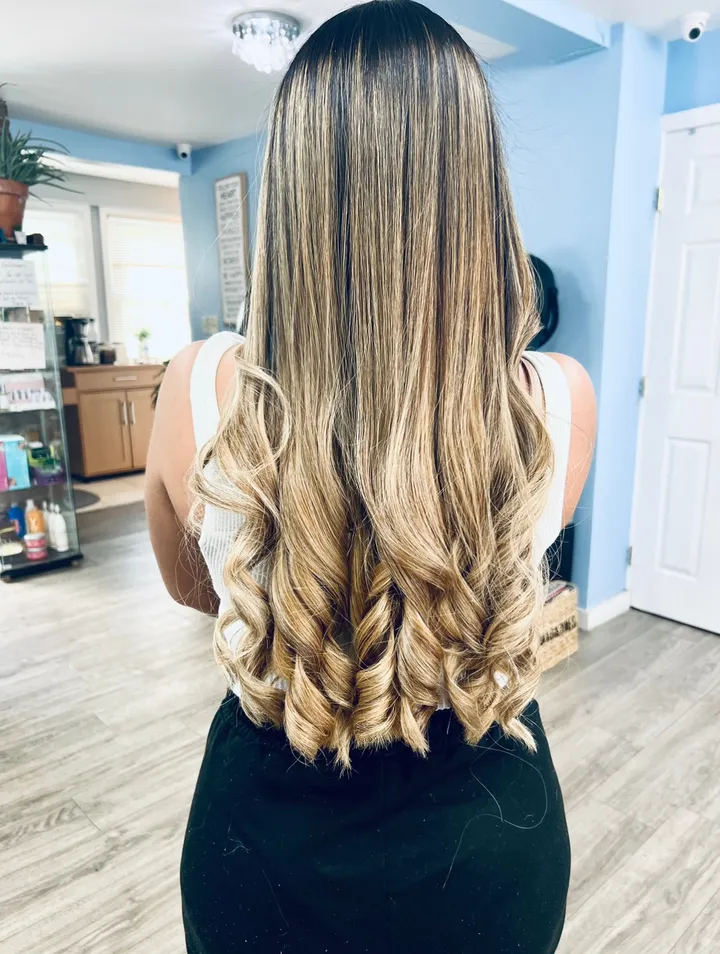 Long dark hair with a caramel balayage, curled into spirals