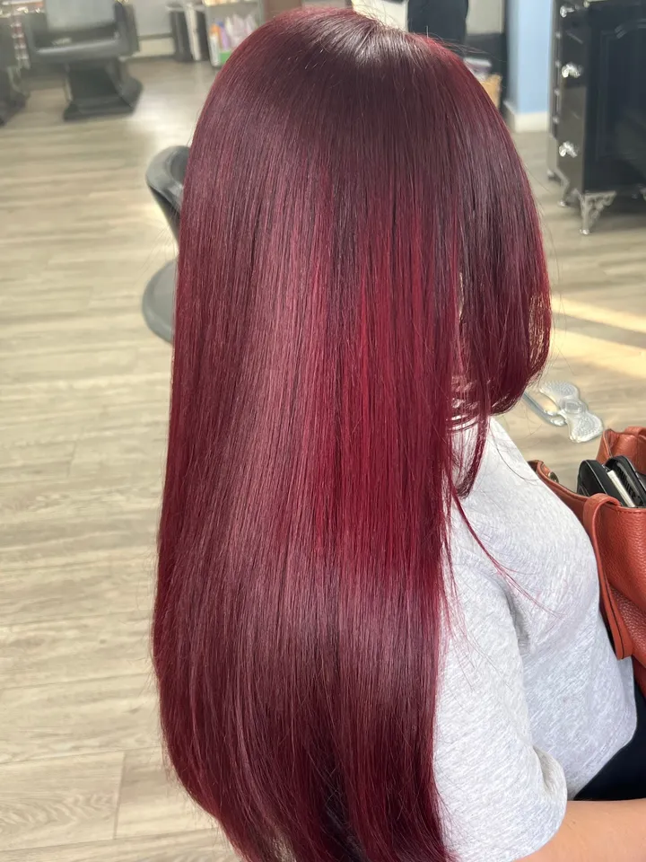 Long, glossy burgundy-red hair worn straight
