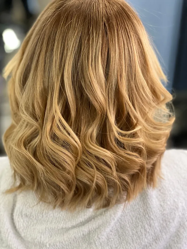 A golden blonde lob styled in loose waves